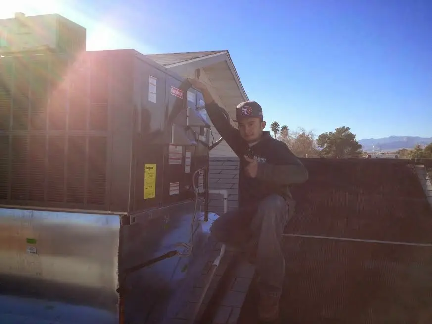 HVAC technician performing Air Duct Repair on a rooftop unit in Maryland Heights